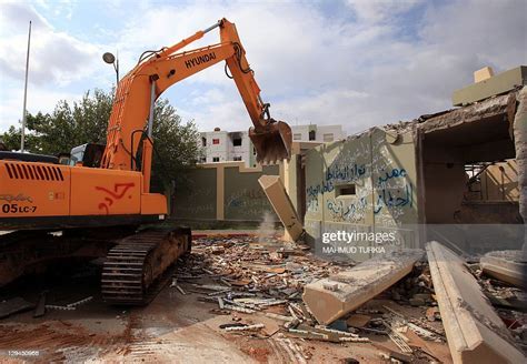 Bulldozer destroys a small building, sounds of the environment