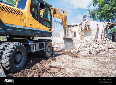 Bulldozer destroys a small building, sounds of the environment